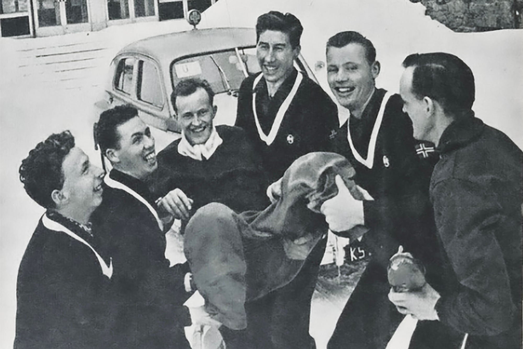 Ski-VM Zakopane, Polen  1962.Bildet viser den svenske skiløperen Assar Rönnlund som bæres på gullstol av norske utøvere i Dale-gensere. Fra venstre: Magnar Lundemo, Einar Østby og Harald Grønningen. (De to til høyre er ikke identifiserte). 
